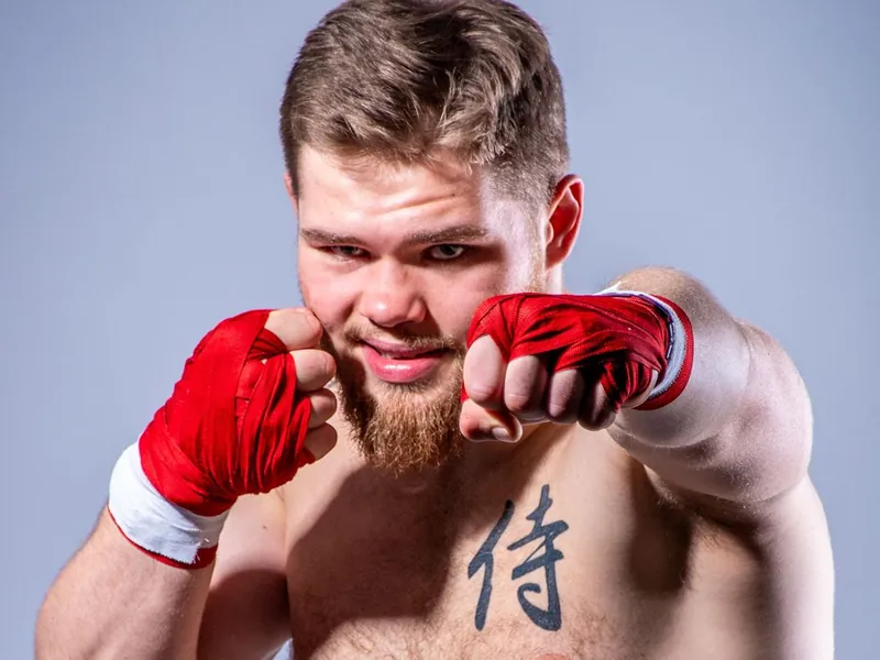 Janek Matyjaszczyk w gardzie, zdjęcie studyjne — widoczny tatuaż 侍 na klatce piersiowej