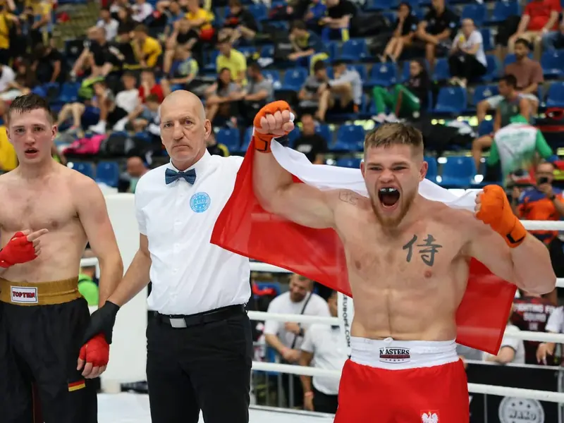 Janek Matyjaszczyk z biało-czerwoną flagą na ringu po wygranej walce