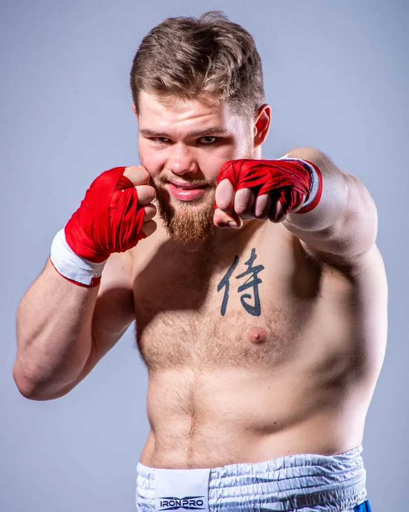 Janek Matyjaszczyk w postawie bokserskiej, z czerwonymi owijkami na dłoniach